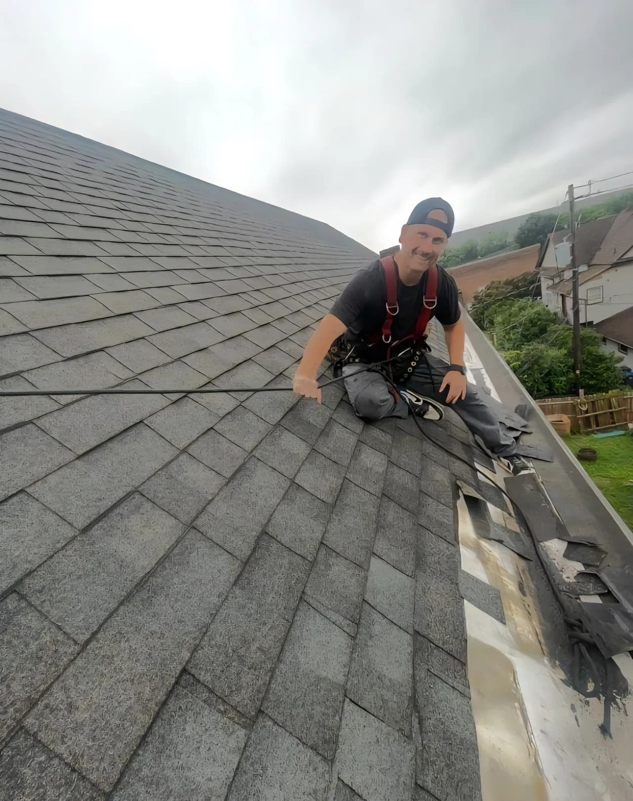 Revive team member harnessed in on a steep shingle roof