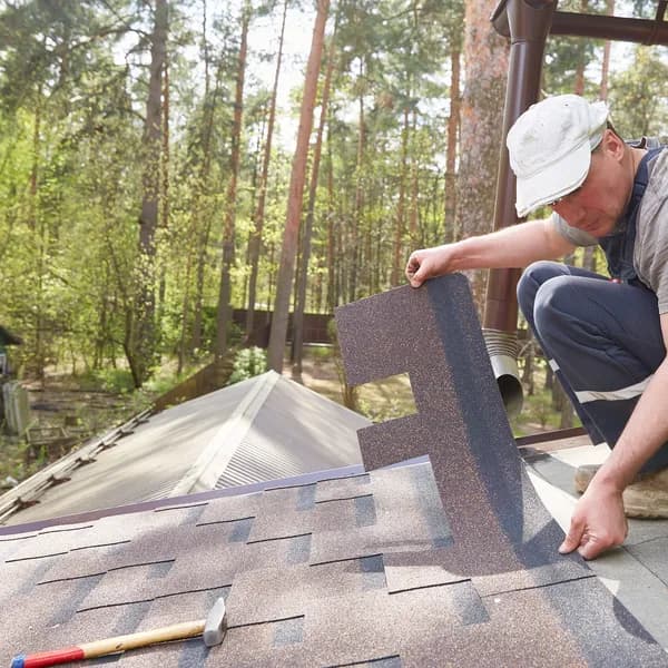 Roofer installing architectural asphalt shingles on a residential roof
