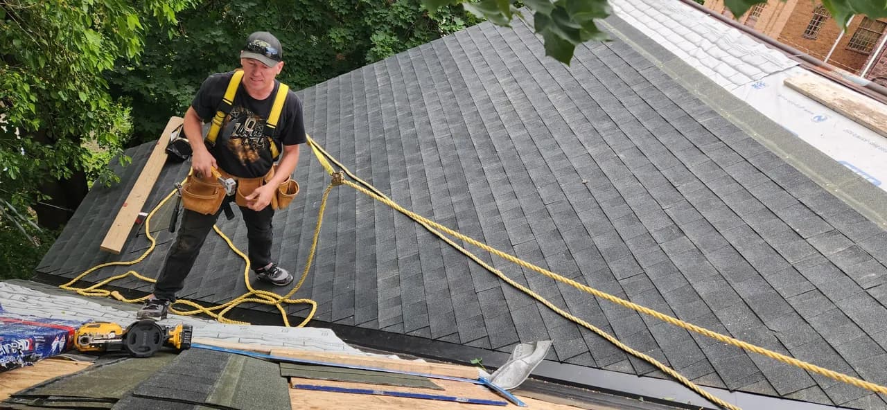 Roofer roped in working on a steep section near the ridge