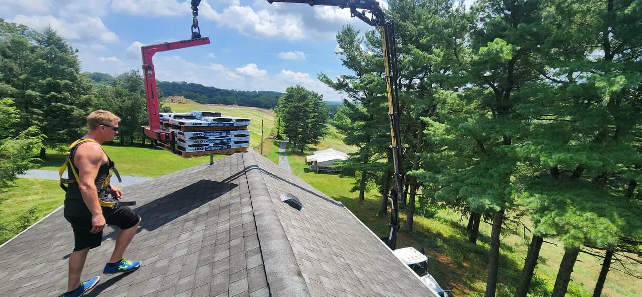 Crane delivering pallet of shingles directly to the roof deck